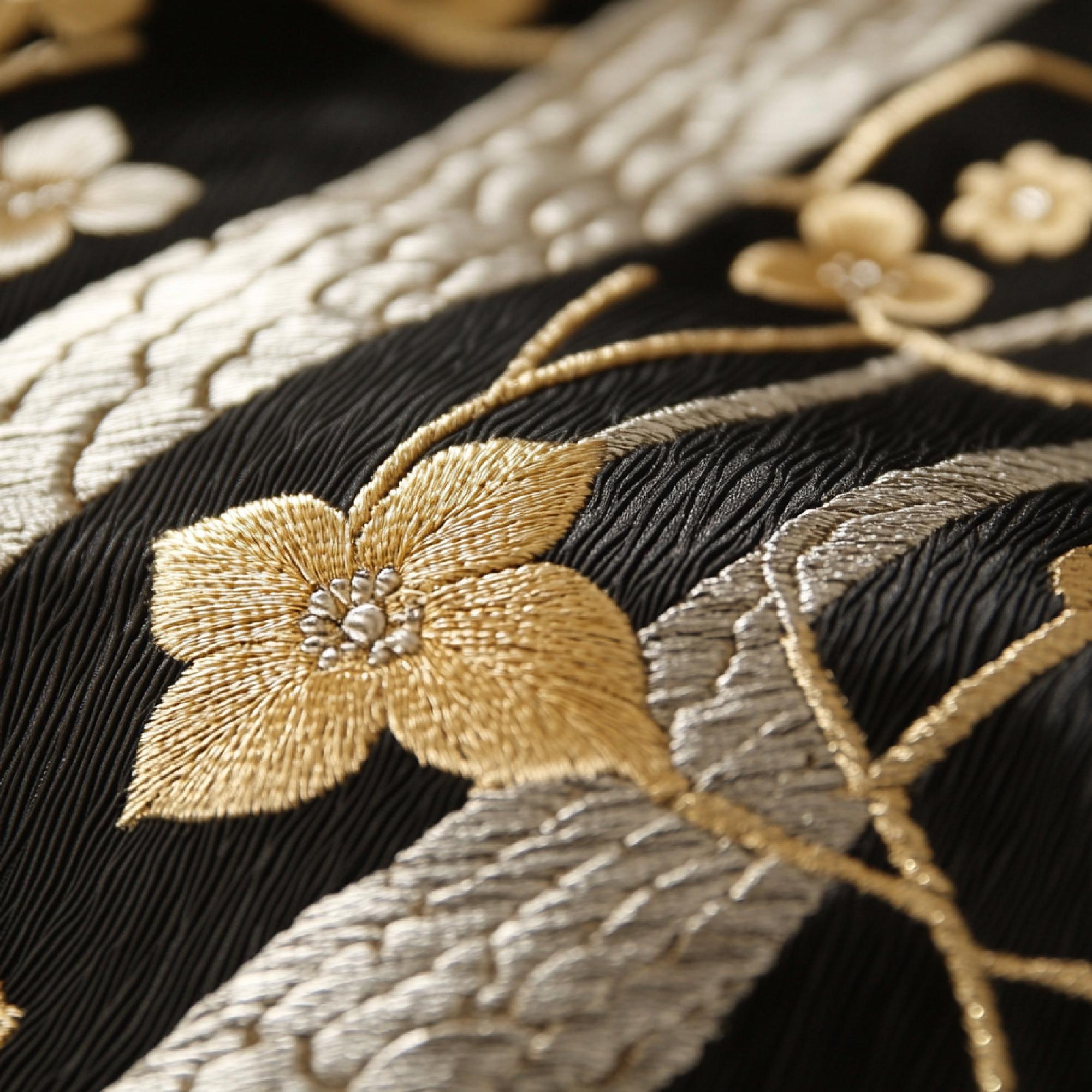 Close-up gold thread monogram on silk